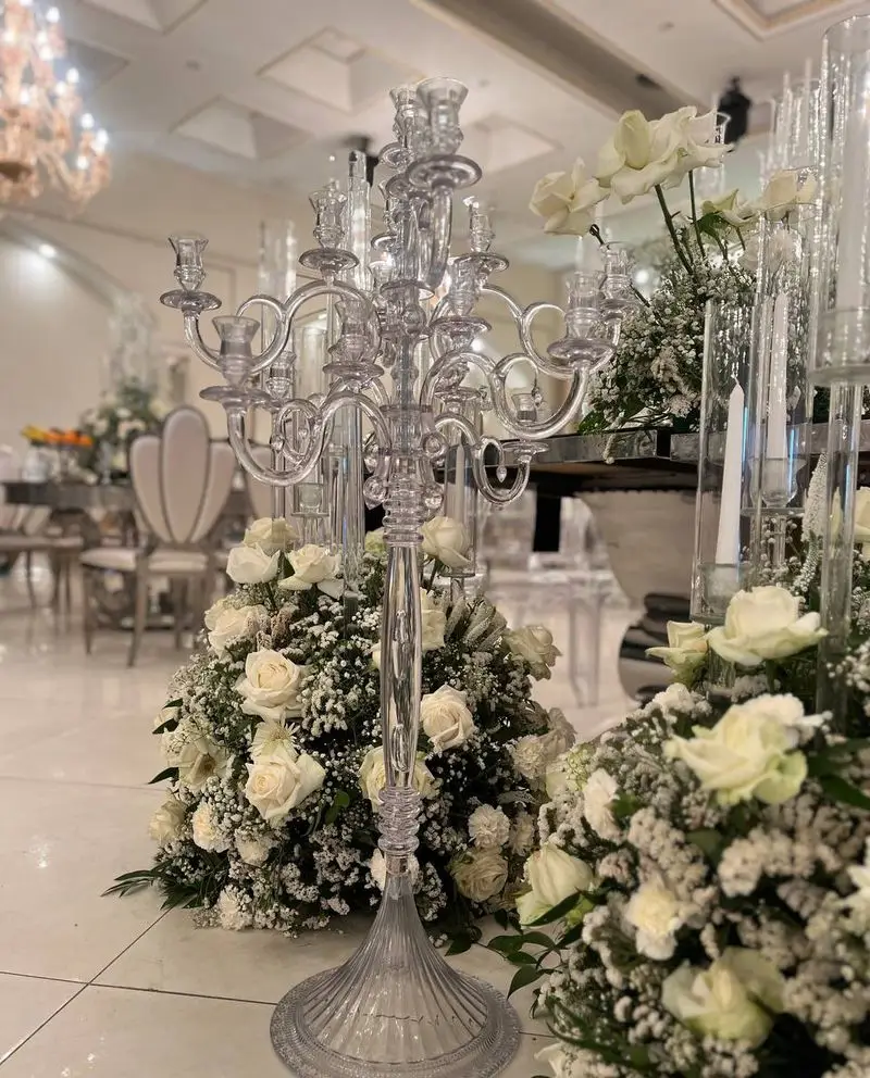 شمعدان‌های شیشه‌ای باشکوه با گل‌آرایی سفید برای مجالس خاص. ظروف کرایه بلادی ارائه‌دهنده لوکس‌ترین لوازم و تجهیزات مراسم شما.
