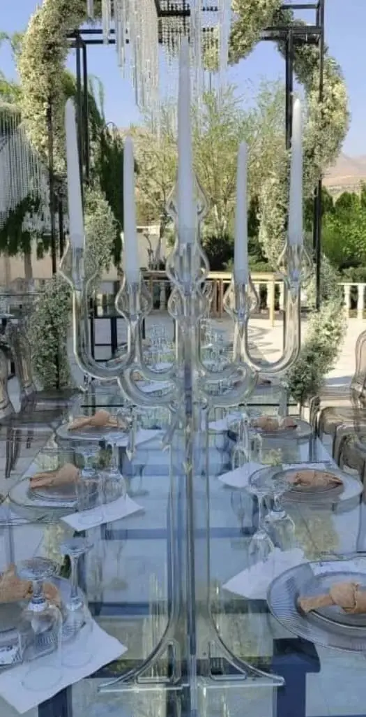 ست لوکس ظروف کرایه بلادی، میز و صندلی شیشه‌ای و کندل‌دان کریستالی برای تزئین خاص مراسم عروسی و عقد در باغ.
