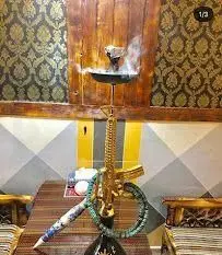 قلیان تفنگی طلایی و جذاب در سفره خانه شهرزاد، قلیانی خاص با طرح اسلحه و دود دلنشین. تجربه ای لوکس در کافه سنتی شهرزاد.