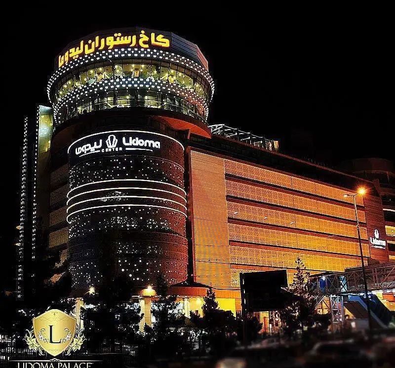 کاخ رستوران لیدوما در شب، نمای خارجی باشکوه و نورانی مرکز خرید لیدوما، رستوران لوکس و مدرن با تابلو روشن.