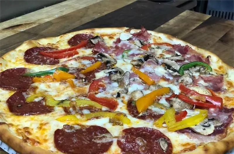 پیتزا مخصوص کافی شاپ مازراتی با پنیر فراوان، کالباس، ژامبون، قارچ و فلفل دلمه‌ای‌های رنگی. یک طعم بی‌نظیر برای شما.