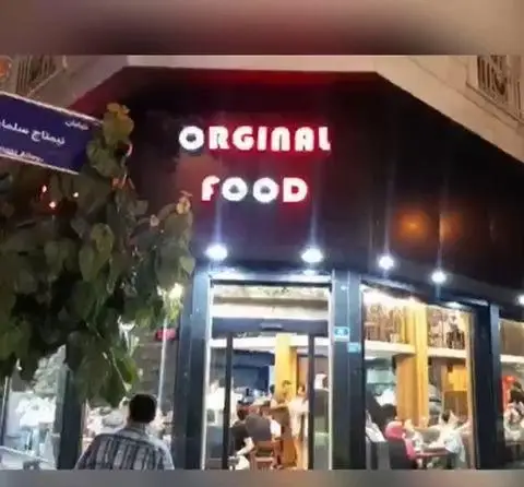 رستوران فست فود پیتزا دکتر آرین اورجینال فود، نمای خارجی شب با تابلوی نئون Orginal Food و محیط داخلی شلوغ و جذاب.