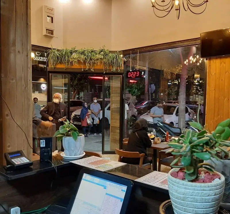 محیط داخلی شلوغ رستوران پیتزا دکتر آرین (اورجینال فود) در تهران، با مشتریان و پیشخوان آماده سرویس‌دهی.