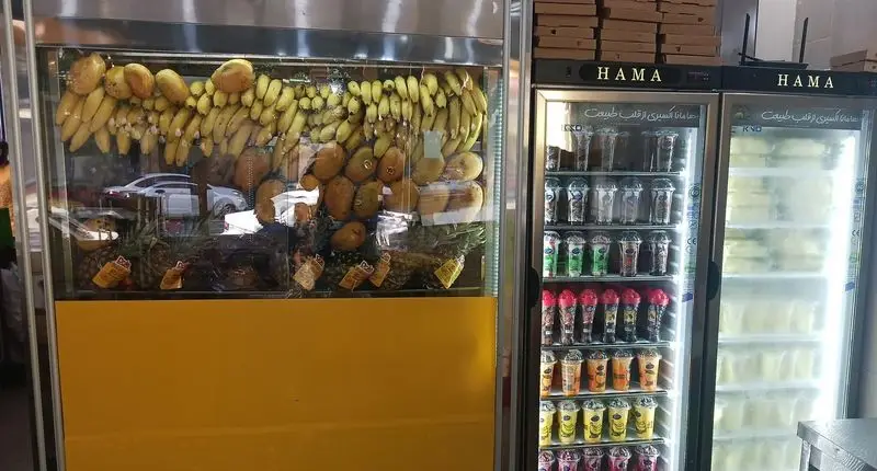 ویترین میوه تازه ننه آقا شهرری با موز، انبه، آناناس و یخچال های آبمیوه و اسموتی های خنک و طبیعی هاما.