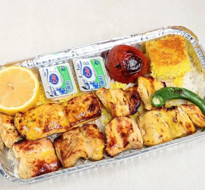 چلو جوجه کباب لذیذ با برنج زعفرانی، گوجه کبابی، لیمو و دوغ کاله از تهیه غذا حامد فود، بهترین کترینگ غذای ایرانی.