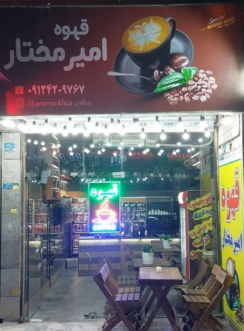 کافه قهوه امیر مختار: تابلوی مغازه با فنجان قهوه، لاته آرت، دانه قهوه و اطلاعات تماس. فضای شیشه ای داخلی با میز و صندلی چوبی.