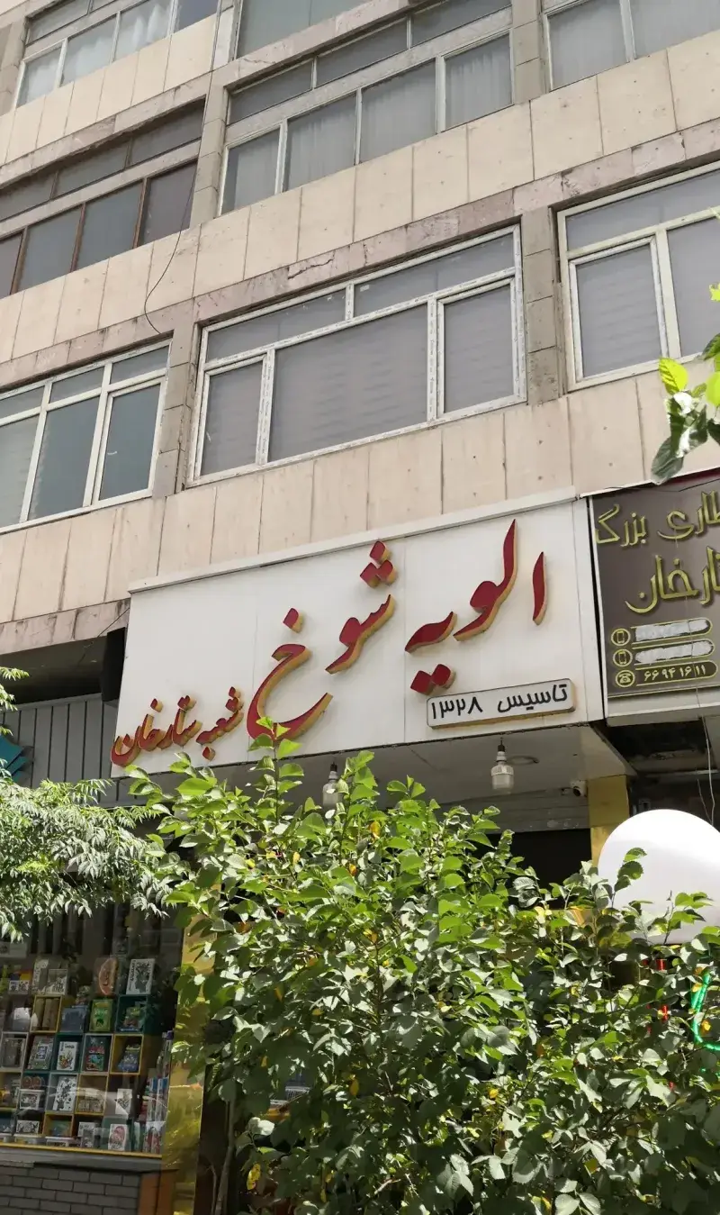 نمای بیرونی کسب و کار "الویه شوخ شعبه ستارخان" (تاسیس ۱۳۲۸)، با تابلوی شاخص و بزرگ. یک مقصد محبوب برای الویه و ساندویچ در منطقه ستارخان.