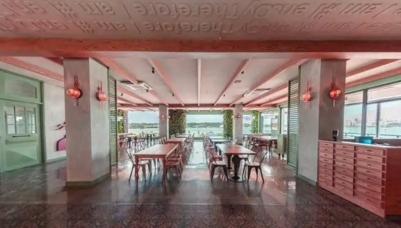 فضای داخلی دنج و مدرن رستوران جو گریل فود با منظره‌ای دلنشین رو به دریا و چیدمان میز و صندلی‌های شیک، مکانی عالی برای تجربه غذاخوری.