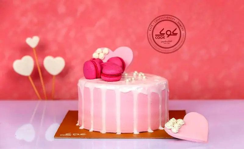 کیک صورتی عاشقانه و خاص ولنتاین با تزئینات ماکارون، قلب و مروارید از محصولات ویژه کافه قنادی کوک.