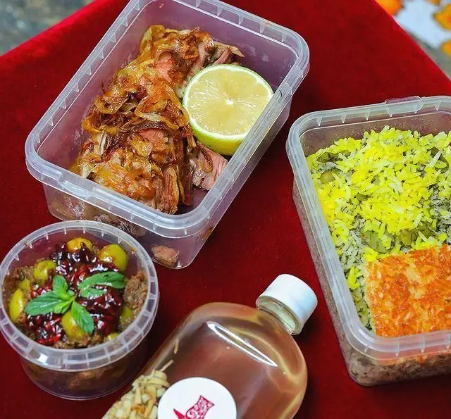 روحی اکسپرس تجریش: غذای آماده شامل خوراک گوشت با پیاز داغ، پلو سبزی با ته‌دیگ و زیتون پرورده در ظروف بیرون‌بر.