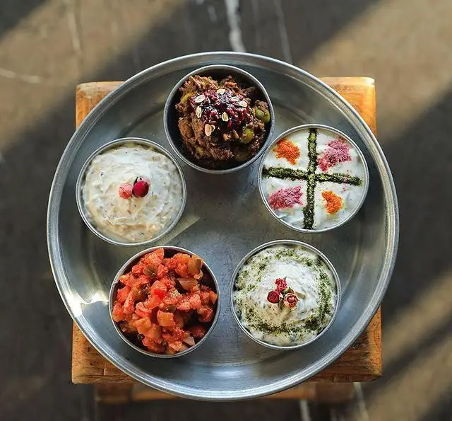 سینی مزه و پیش‌غذاهای متنوع روحی اکسپرس تجریش شامل ماست‌های طعم‌دار، زیتون پرورده و سالاد تازه ایرانی در تهران.