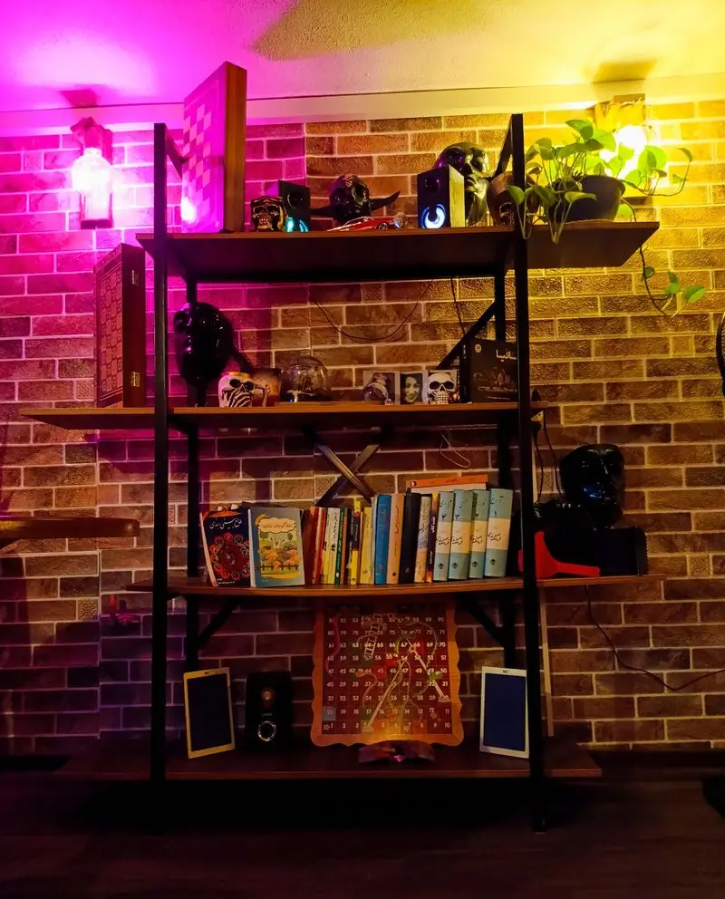 دکوراسیون جذاب کافه گیم شو و کافه کتاب با قفسه پر از کتاب، بازی‌های رومیزی و جمجمه‌های تزیینی. ایده‌آل برای مافیا گیم نت.