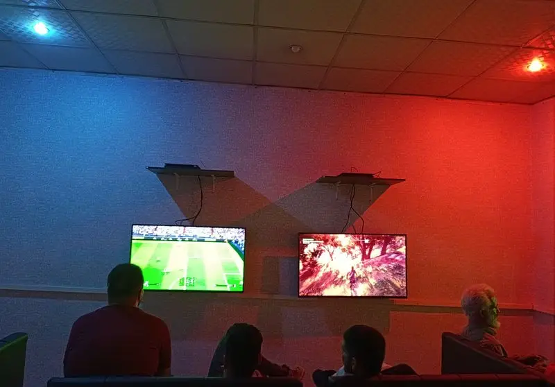 فضای هیجان‌انگیز کافه گیم شو و گیم نت مافیا با دو بازی ویدیویی فوتبال و ماجراجویی، نورپردازی خاص و تجربه گیمینگ عالی.