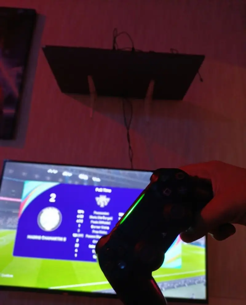 بازی فوتبال مهیج با پلی‌استیشن در کافه گیم شو، گیم نت ما. کنترلر در دست و آماده رقابت برای علاقه‌مندان به بازی و سرگرمی.