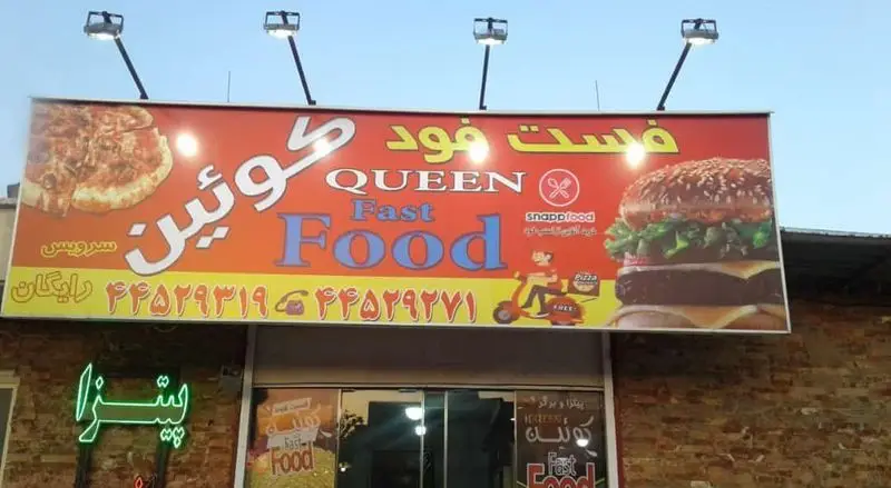 تابلوی بزرگ فست فود کوئین با عکس پیتزا و همبرگر لذیذ، ارائه دهنده سرویس رایگان، سفارش آنلاین و شماره تماس.