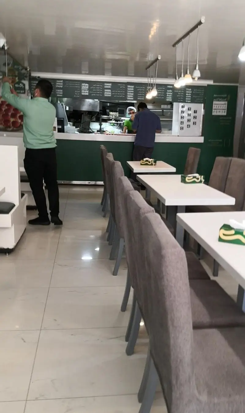 فضای داخلی تمیز و مدرن فست فود باگت با پیشخوان سفارش، منوی غذا و میز و صندلی‌های راحت برای مشتریان. محیطی دلنشین برای صرف غذای باکیفیت.