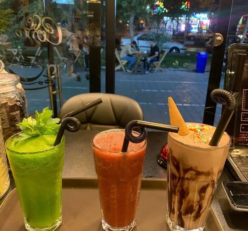 نوشیدنی‌های خنک و متنوع کافه گلد: اسموتی نعنا، اسموتی توت‌فرنگی و میلک‌شیک شکلات در فضای دلنشین شب کافه.