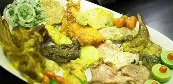 سینی شکیل و پر از انواع غذاهای سنتی و خوشمزه رستوران اجاق باشی شامل کباب، خورشت و غذاهای محلی ایرانی با تزیین تازه