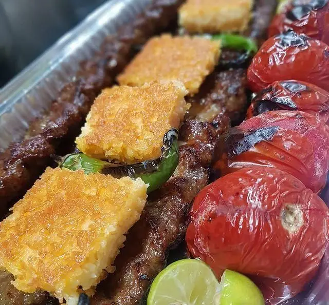 کباب کوبیده لذیذ کترینگ شاهین با ته چین زعفرانی، گوجه و فلفل کبابی. غذای اصیل ایرانی برای سفارش آنلاین.