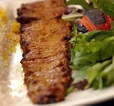 کباب برگ اعلا از کترینگ شاهین، غذای سنتی و اصیل ایرانی، سرو شده با برنج ایرانی زعفرانی و دورچین مجلسی، طعمی بی‌نظیر.