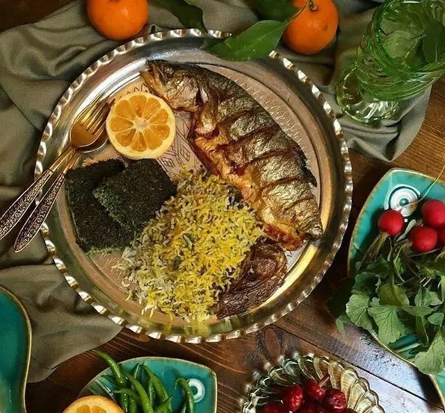 غذای کترینگ شاهین: ماهی سرخ‌شده، پلو زعفرانی و کوکو سبزی با مخلفات متنوع. مناسب مهمانی و سفارش غذا.