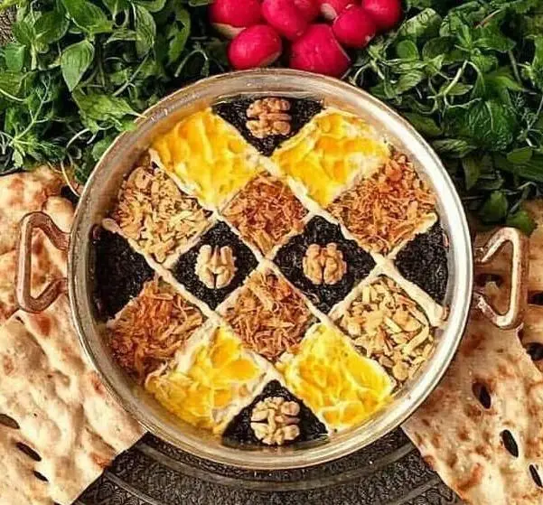 کترینگ شاهین: پلوی مجلسی با دیزاین خیره‌کننده آجیل، زعفران و زرشک، در کنار سبزی خوردن تازه، نان و تربچه برای سفره‌ای اصیل.