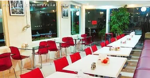 فضای داخلی شیک و مدرن کبابی جیگر طهرون با چیدمان میز و صندلی‌های راحت قرمز و نورپردازی دلنشین آماده پذیرایی از شما.