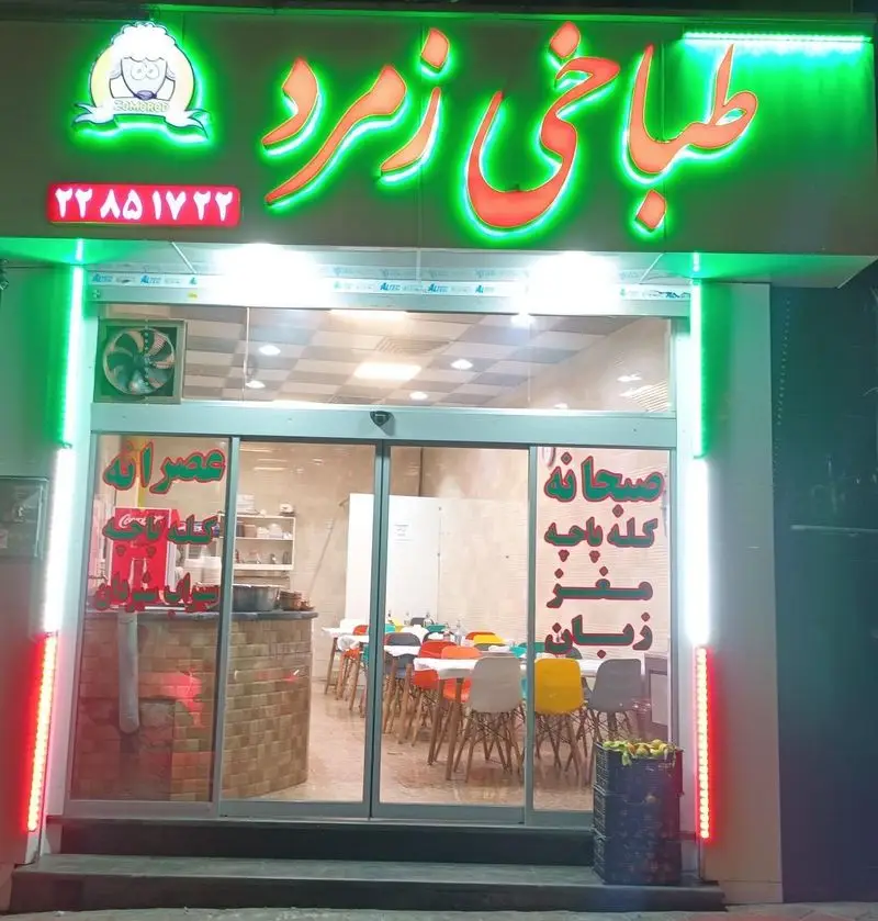 نمای جلوی طباخی زمرد شبانه روزی با تابلوی نئون سبز و قرمز، لوگو گوسفند و شماره تماس 22851722. متخصص کله پاچه، مغز، زبان، صبحانه و عصرانه.