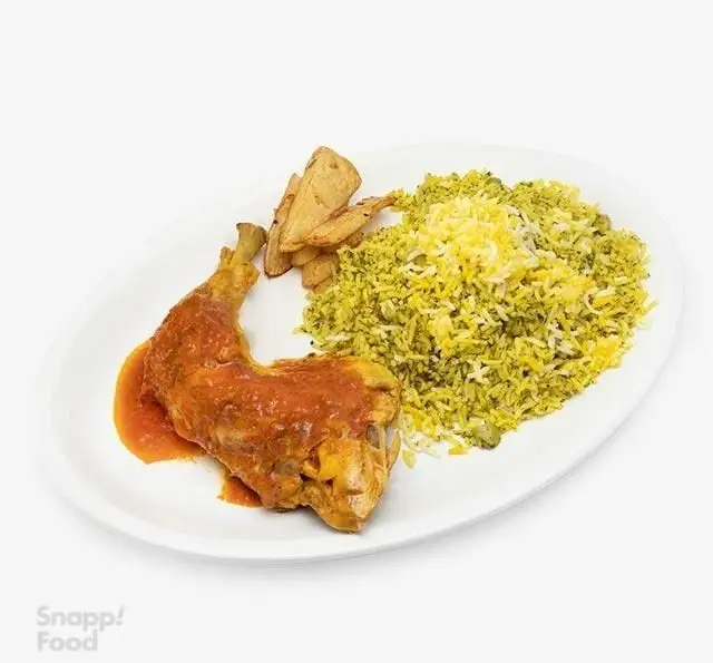 رستوران الف: چلو مرغ مجلسی با ران مرغ در سس گوجه، سبزی پلو زعفرانی و سیب زمینی سرخ شده، یک غذای سنتی ایرانی لذیذ و دلپذیر.