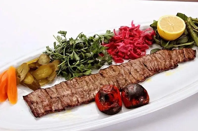 کباب برگ درجه یک رستوران الف با مخلفات تازه و خوش‌طعم: گوجه کبابی، سبزی، ترشی کلم، خیارشور، هویج و لیمو. تجربه‌ای دلنشین از غذای ایرانی.