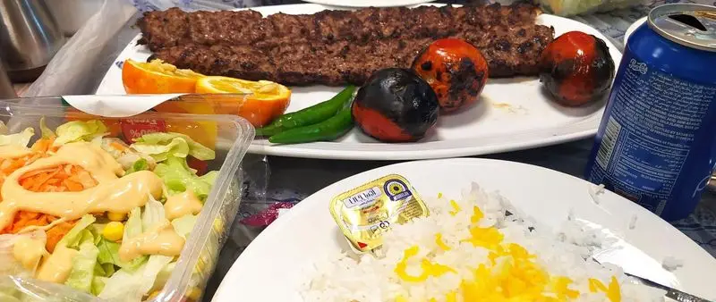 کباب کوبیده اصیل ایرانی، برنج زعفرانی معطر، سالاد فصل تازه و گوجه کبابی. یک وعده غذایی کامل و لذیذ همراه نوشیدنی از پیتزا سیسیز.