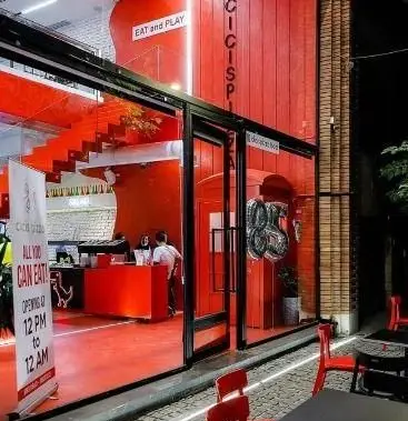 نمای بیرونی جذاب رستوران پیتزا سیسیز در شب با دکوراسیون مدرن قرمز و تابلو 'All You Can Eat' برای تجربه بهترین پیتزا.