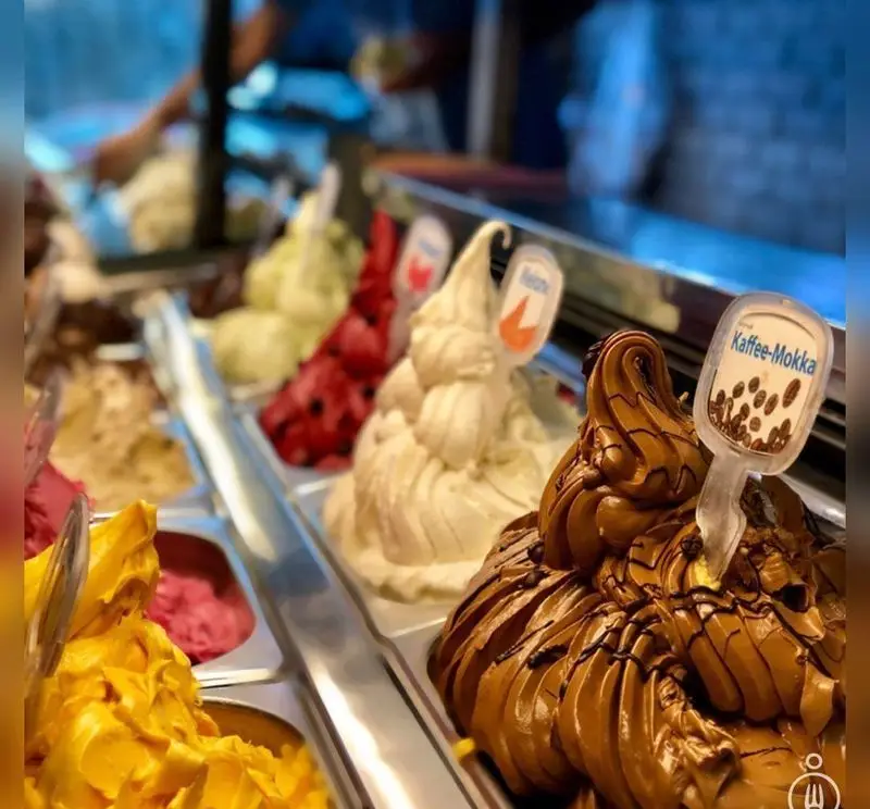 ویترین بستنی فروشی سان مار کو با مجموعه‌ای چشم‌نواز از طعم‌های متنوع و تازه، از جمله بستنی قهوه موکا، شکلات و میوه‌های فصلی، آماده سرو.