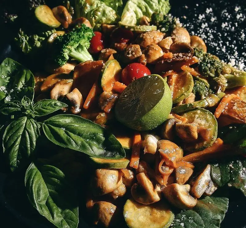 سفارش غذای سالم و گیاهی از فست فود د ل پ: خوراک سبزیجات تازه شامل قارچ، بروکلی، کدو، گوجه و ریحان با چاشنی لیمو. خوشمزه و رژیمی.