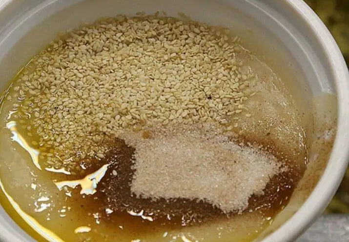 مواد اولیه حلیم شاطر احمد، شامل کنجد تازه، شکر دانه ریز و روغن حیوانی مرغوب در کاسه. آماده سازی حلیم سنتی و خوش طعم شاطر احمد.