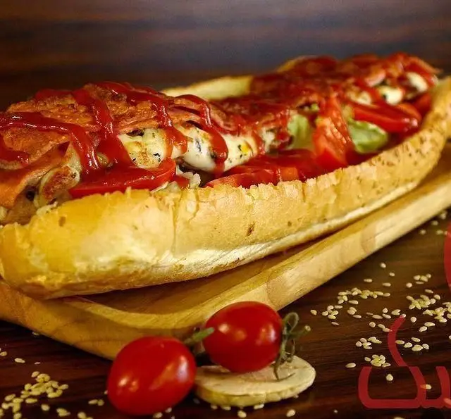 ساندویچ ویژه و بسیار لذیذ فست فود اونیک، شامل نان تازه، پنیر آب شده، کالباس، گوجه فرنگی و سس کچاپ فراوان.