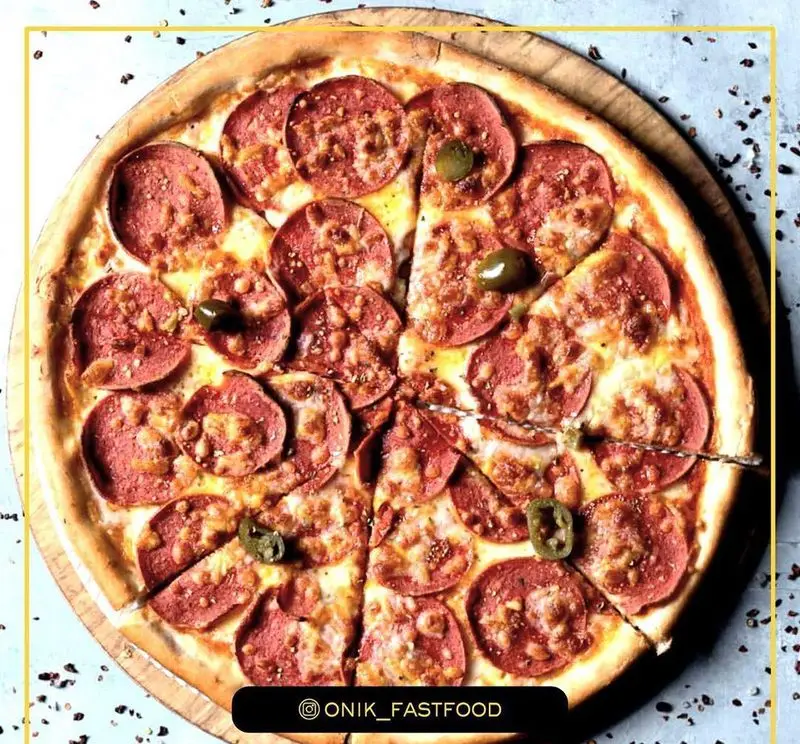 تصویر پیتزا پپرونی داغ و لذیذ فست فود اونیک با پنیر فراوان و فلفل هالوپینو، بهترین انتخاب برای یک وعده غذایی سریع و خوشمزه.