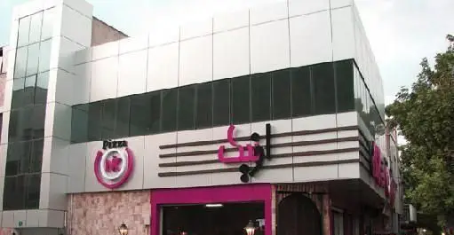 نمای بیرونی شیک فست فود و رستوران پیتزا اونیک، با تابلوی بزرگ و لوگوی "Pizza Onik" و رنگ‌های صورتی جذاب در ساختمان مدرن.