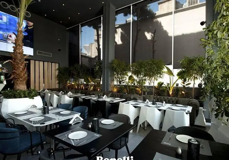 دکوراسیون داخلی رستوران بنلی لانژ با میز و صندلی‌های مدرن، چیدمان شیک و گل و گیاه سرسبز، فضایی دلنشین برای صرف غذا.