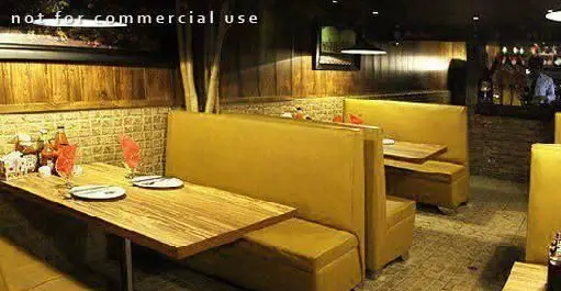 نمایی از فضای داخلی رستوران ایتالیایی کوزی کورنر با میزهای چوبی، مبلمان راحتی زرد رنگ و دکوراسیون گرم و دلنشین، ایده‌آل برای یک تجربه خاص.