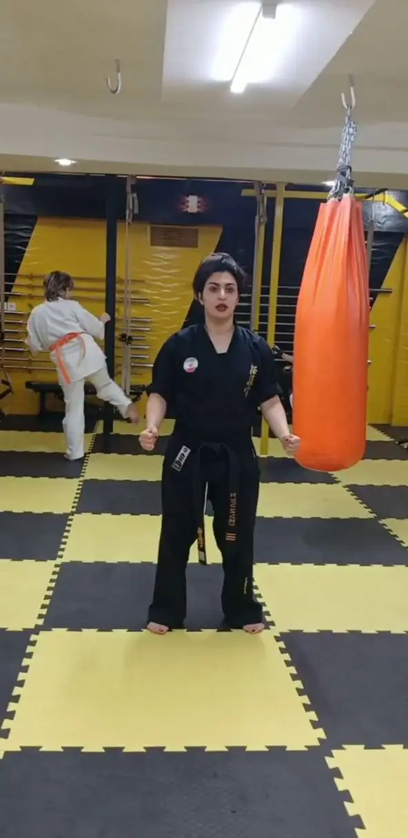 مربی کاراته بانوان در حال آموزش دفاع شخصی و هنرهای رزمی در باشگاه ورزشی گلایل. تمرینات کیک بوکسینگ برای بانوان.