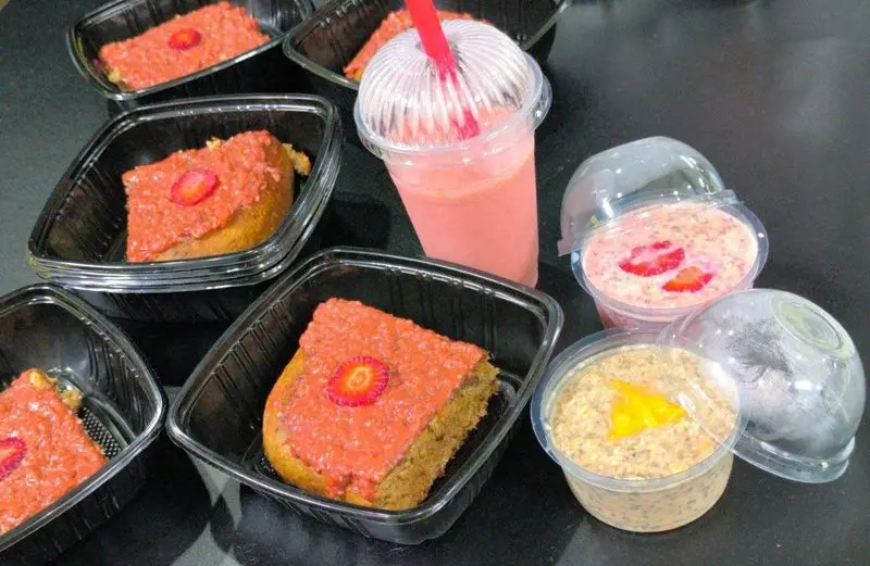 مجموعه‌ای از وعده‌های غذایی آماده و سالم باشگاه ورزشی گلایل شامل کیک توت فرنگی، اسموتی میوه و پودینگ چیا مغذی.