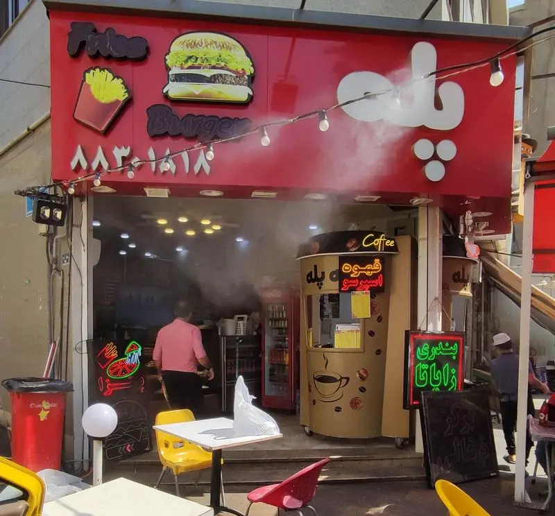 نمای جذاب فست فود پله با منوی متنوع برگر، سیب زمینی سرخ کرده و کافه پله جهت سرو قهوه اسپرسو. مکانی ایده‌آل برای غذای آماده و نوشیدنی.