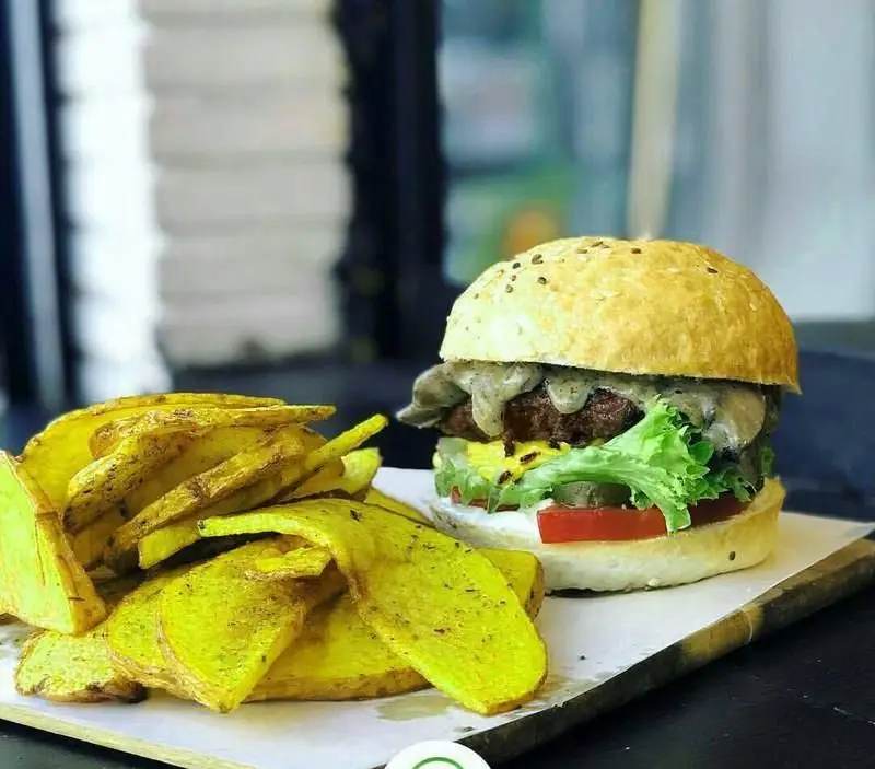 برگر مخصوص رستوران ایتالیایی ماسا سالاد بار با سس قارچ، کاهو، گوجه، پنیر و نان کنجدی، کنار سیب زمینی سرخ کرده.