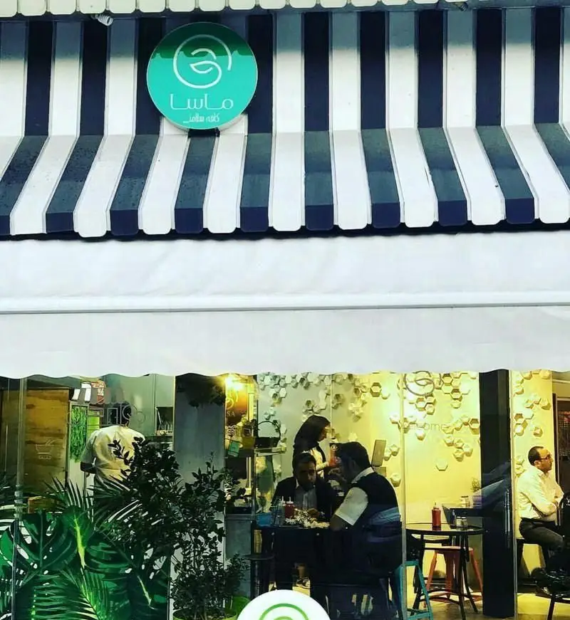 نمای بیرونی رستوران ایتالیایی ماسا سالاد بار، با آلاچیق شیک و لوگوی برند، مشتریان را در فضایی دلنشین شب هنگام جذب می کند.