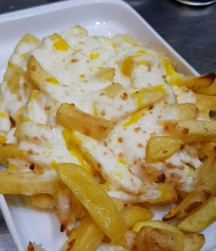 تصویری از سیب زمینی سرخ کرده پنیری ویژه گزینگ برگر، با پنیر موزارلا و چدار آب شده، یک ساید دیش لذیذ و پرطرفدار.