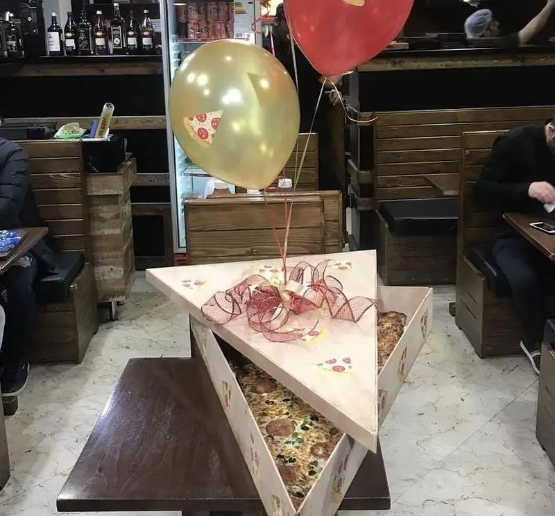 بسته بندی لوکس و جذاب پیتزا در جعبه‌های مثلثی گزینگ برگر. هدیه‌ای خاص برای تولد با بادکنک‌های پیتزا در کافه.