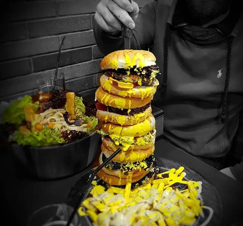 گزینگ برگر: برج برگر غول‌پیکر با سس پنیر و سیب‌زمینی، یک چالش غذایی فوق‌العاده برای عاشقان فست فود.