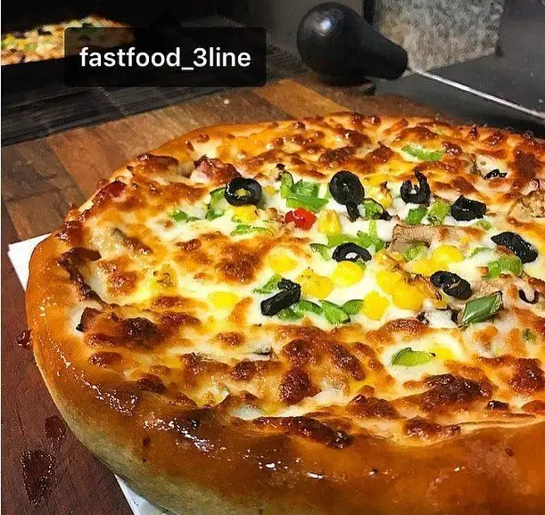 پیتزای ویژه و لذیذ فست فود 3 لاین با کراست طلایی، پنیر ذوب شده، زیتون سیاه، ذرت شیرین و فلفل دلمه ای تازه.