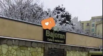 تصویر تابلوی زیبای کافی شاپ و رستوران باژوران در یک روز سرد و برفی زمستان، محلی ایده‌آل برای استراحت و صرف غذا.